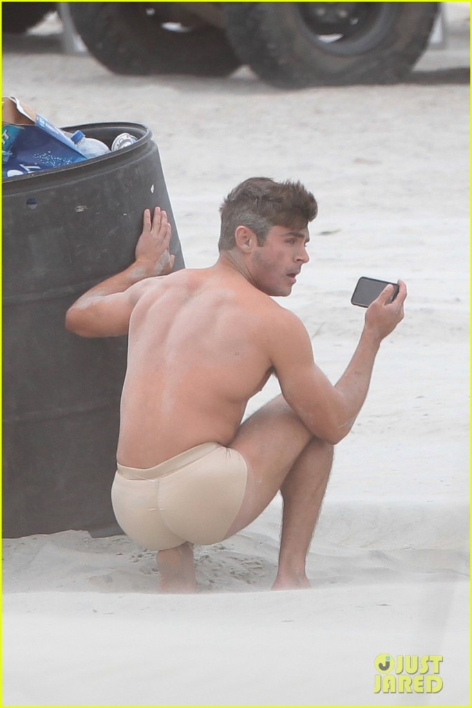 Zac Efron wears just a pair of nude underwear and a stuffed toy to protect his modesty as he films a beach scene for 'Dirty Grandpa'