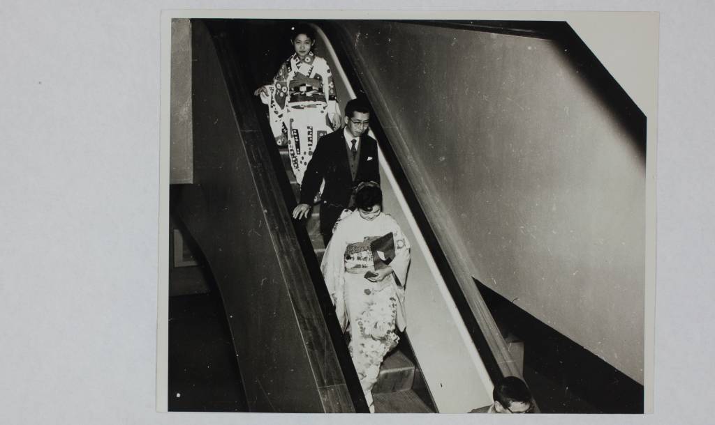 Foto de arquivo de três pessoas descendo escada rolante no Pavilhão da Bienal