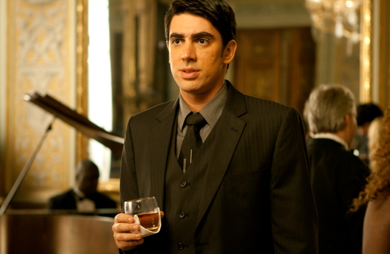 Marcelo Adnet de terno em cena de filme.