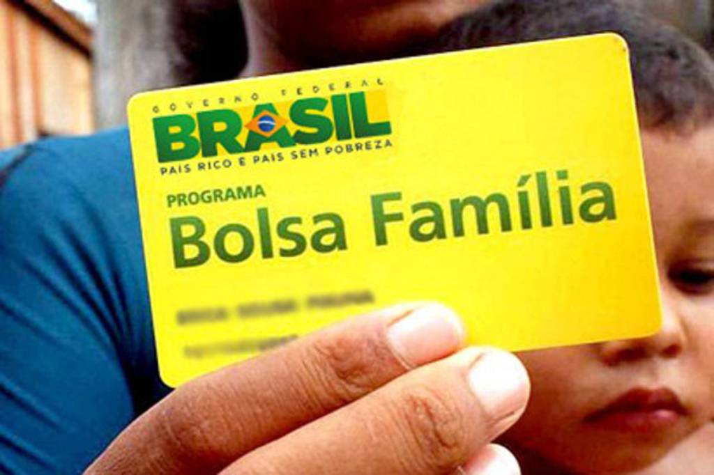 Mulher exibe cartão de beneficiários do Bolsa Família