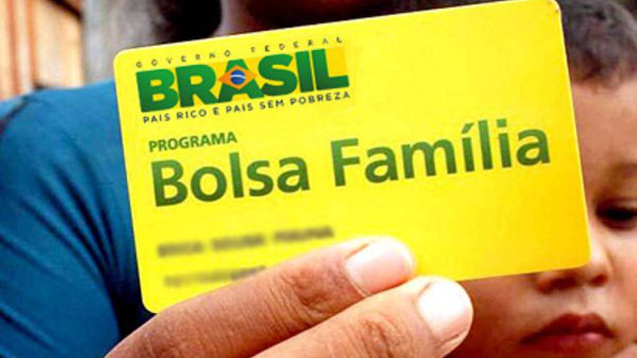 Mulher exibe cartão de beneficiários do Bolsa Família