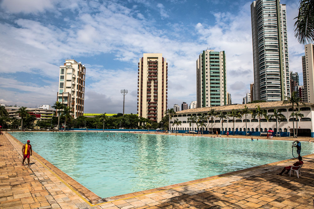 A foto mostra uma piscina em dia ensolarado