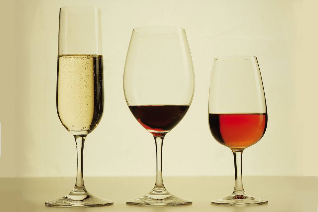 Montagem em fundo branco com quatro garrafas de vinho.