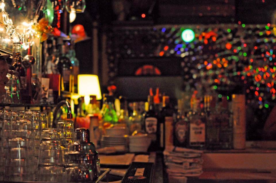 Bar com espelho, garrafas e luzes coloridas