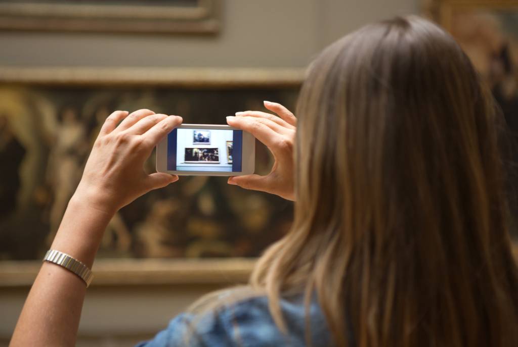 Mulher fotografando no museu