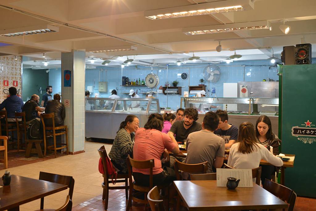 Espaço de peixaria com mesas em frente, montadas como um restaurante