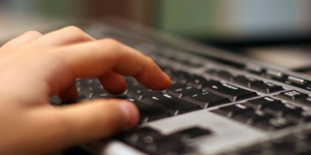 Foto exibe um dedo em teclado de computador.