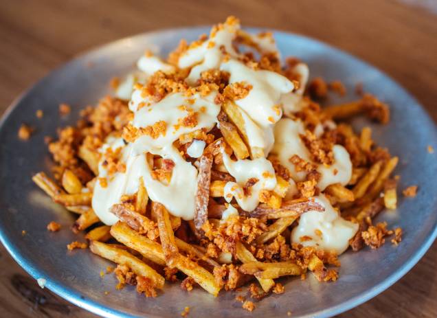 Cheezy fries: batatas fininhas lambuzadas de queijo gruyère com bacon moído Cheezy fries: batatas fininhas lambuzadas de queijo gruyère com bacon moído
