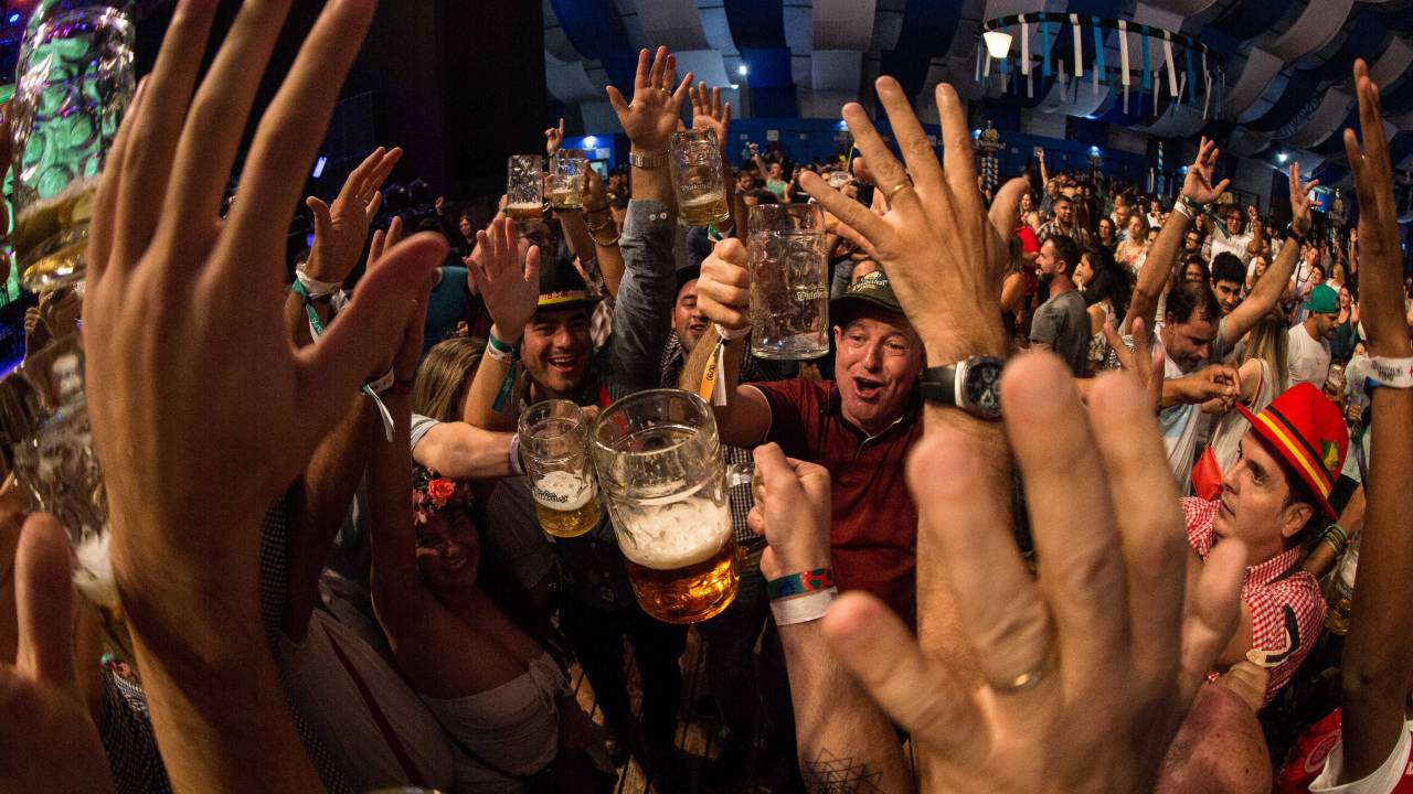 Muitas pessoas aglomeradas com cerveja na mo e reunidas