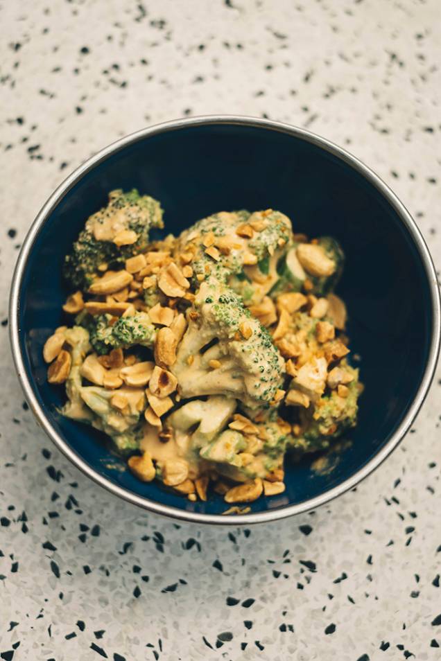 Brócolis cozidos: hortaliça vem com molho de pimenta gochugaru e amendoim com a semente salpicada