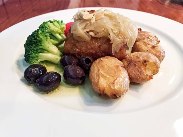 Bacalhau à lagareiro: posta do pescado com cebola dourada, batata ao murro, tomate confit, alho laminado e brócolis verdinho