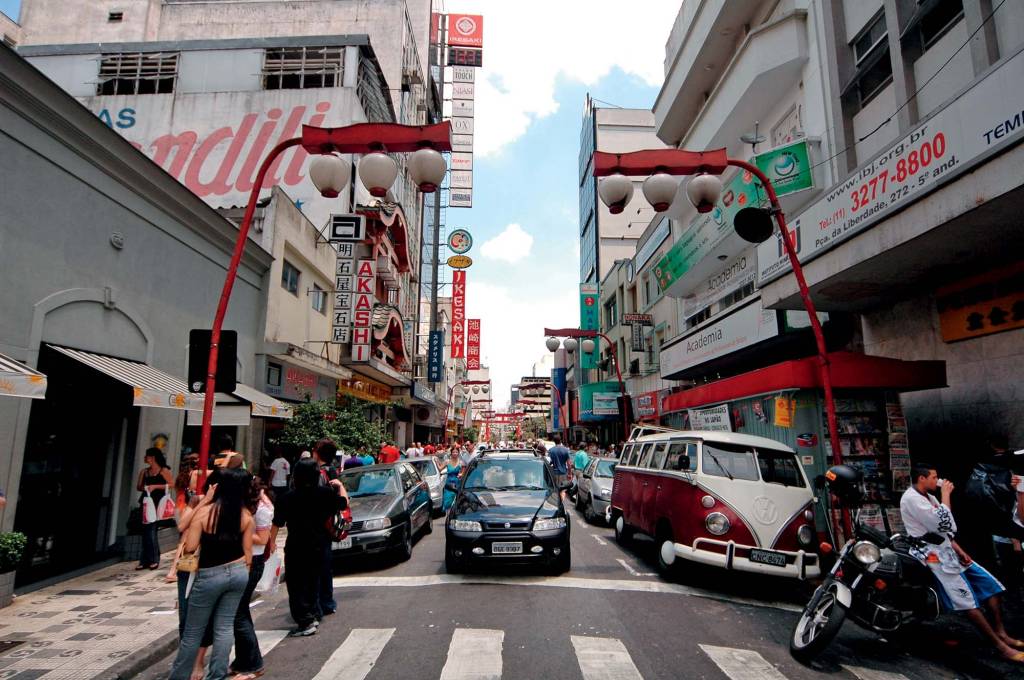 Imagem mostra uma rua no bairro da Liberdade com carros estacionados.