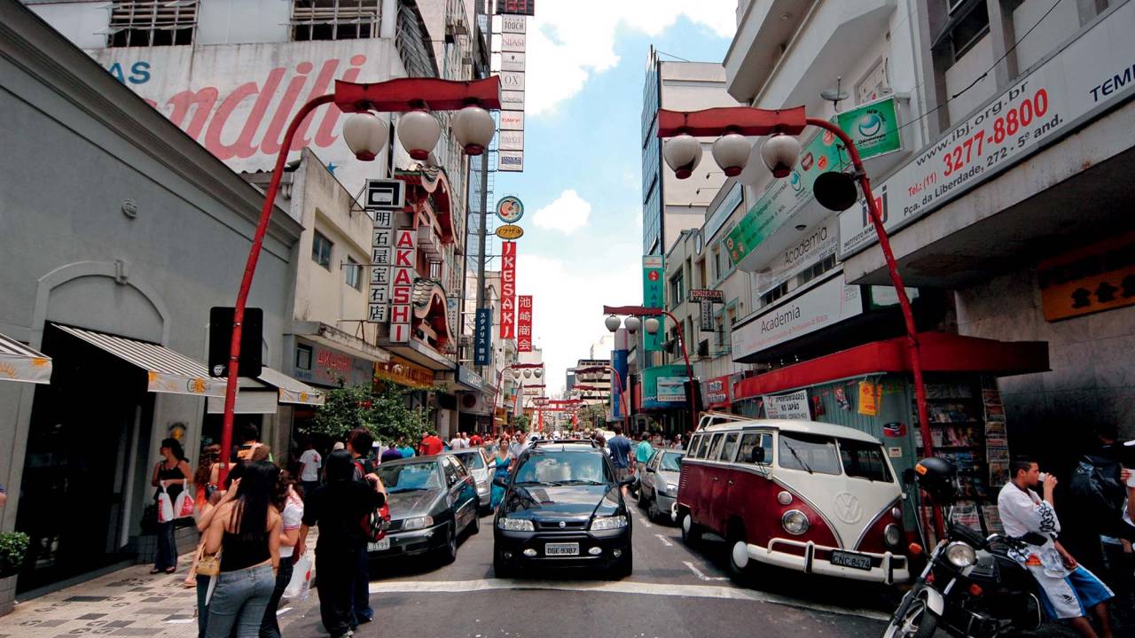 Imagem mostra uma rua no bairro da Liberdade com carros estacionados.