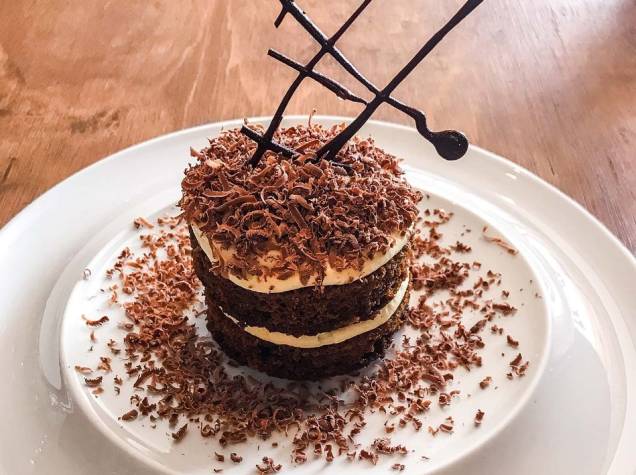 Releitura de tiramisu: bolo de café embebido em calda de café e licor 43, finalizada com creme de mascarpone, baunilha e raspas de chocolate ao leite Releitura de tiramisu: bolo de café embebido em calda de café e licor 43, finalizada com creme de mascarpone, baunilha e raspas de chocolate ao leite