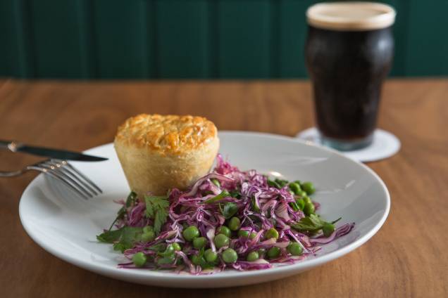 Guinness pie: tortinha que lembra a de empada recheada com picadinho de carne cozida na cerveja preta, acompanhada de salada de repolho-roxo e ervilha