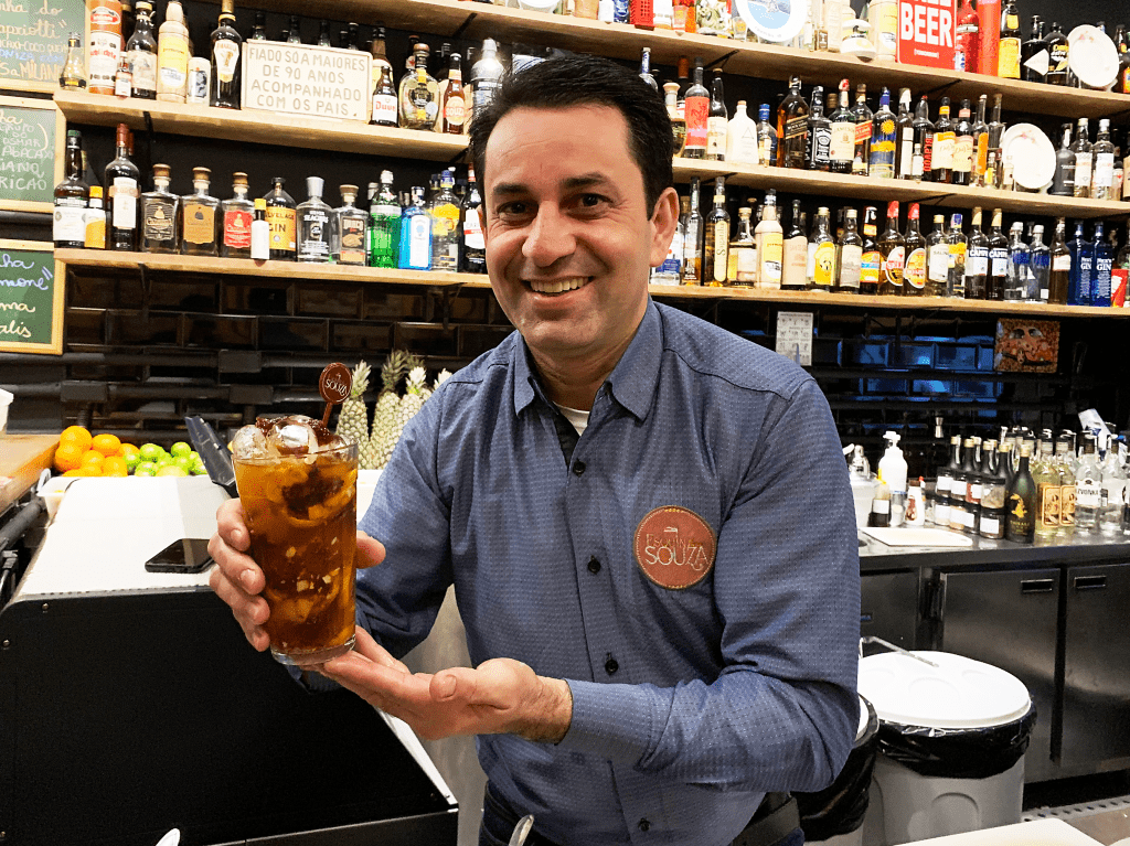 Homem segura caipirinha em bar