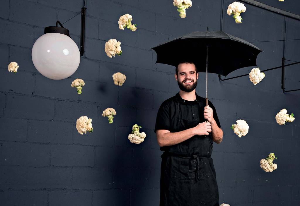 Chef de avental segura guarda-chuva em uma 