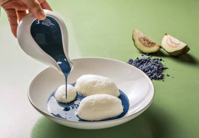 prato branco com bolas brancas de merengue sendo cobertos por creme inglês azul