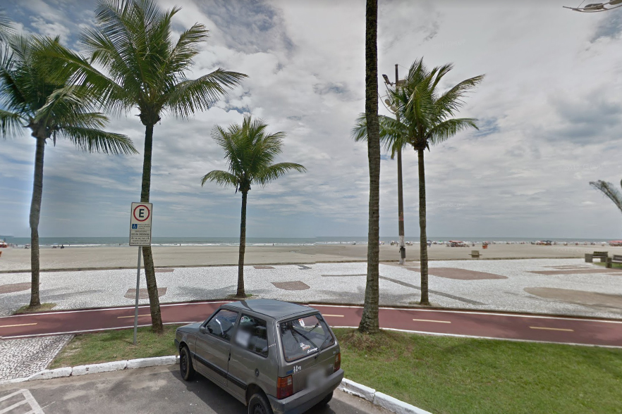 A imagem mostra a praia de Praia Grande, com um carro estacionado