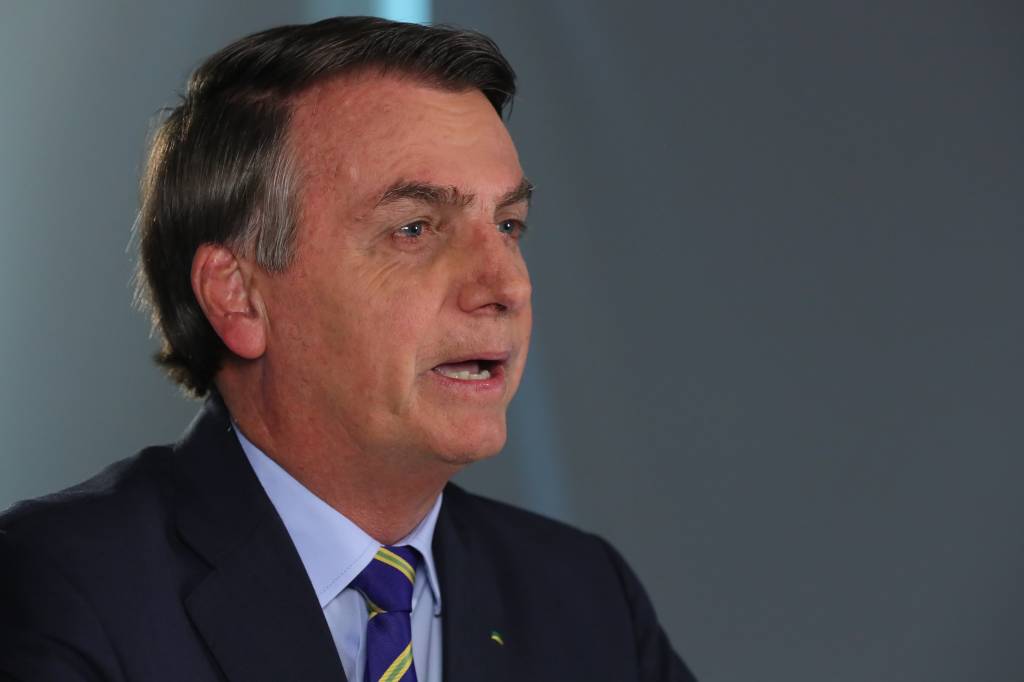 Imagem mostra Bolsonaro, de terno e gravata, olhando para câmera em estúdio de TV, enquanto grava pronunciamento