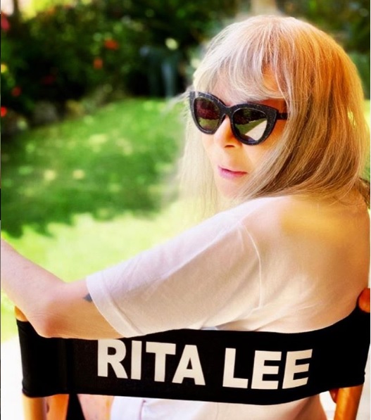 Imagem mostra Rita Lee sentada em cadeira com o seu nome