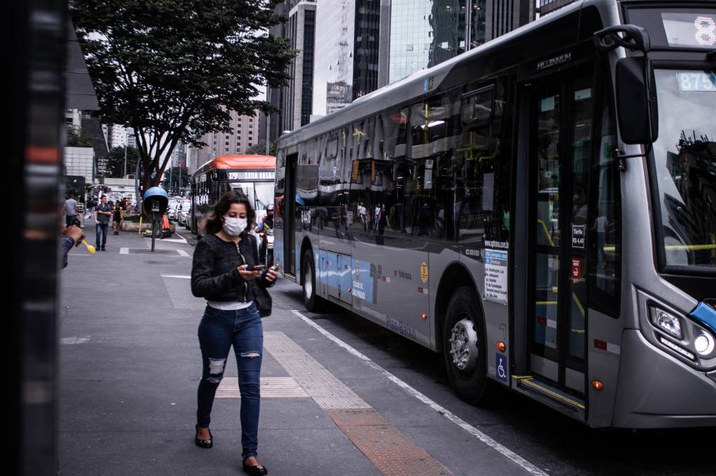 Protegidos com máscaras por causa da pandemia do coronavírus paulistanos caminham na Avenida Paulista,