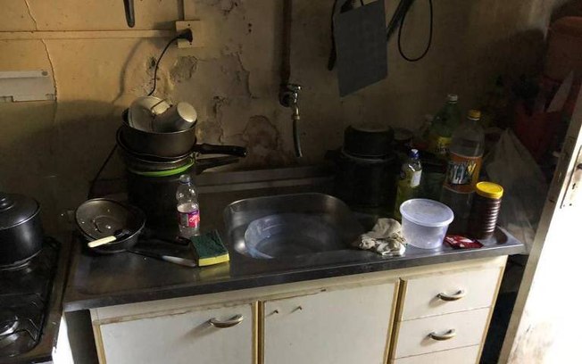 Imagem mostra suja pia de cozinha, com paredes descascadas