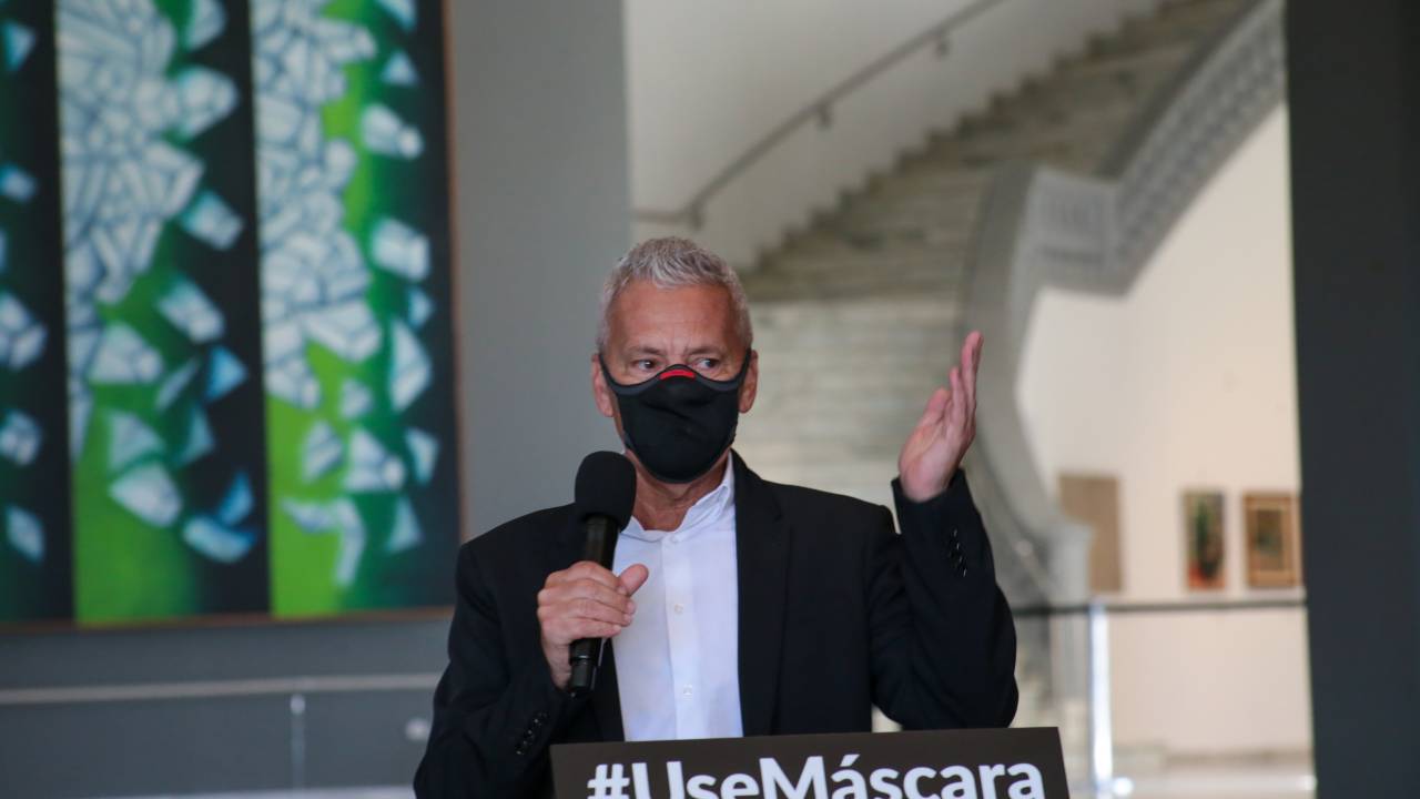 Gabbardo usa máscara e fala ao microfone em coletiva de imprensa