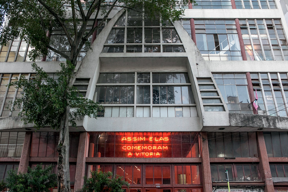 Imagem mostra fachada de prédio, com árvores na calçada