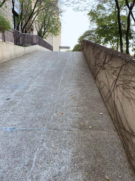 O Parque Cidade Jardim: paredão de garagens para a rua, onde balizas improvisam “calçada” para o pedestre, que não tem espaço nem na rampa