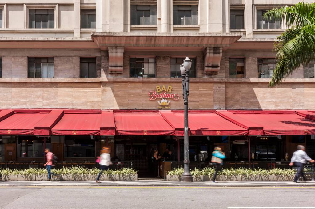 Imagem mostra fachada de bar com toldos vermelhos