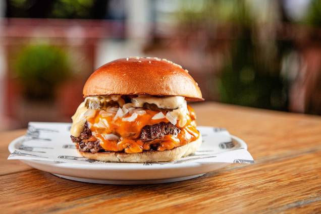 O j.r. burger traz dois discos finos de carne com queijo americano, cebola, picles e molho