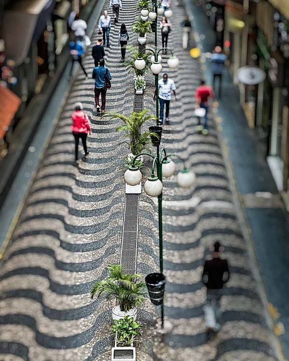 A imagem mostra o calçadão no Centro de São Paulo visto do alto com pessoas andando