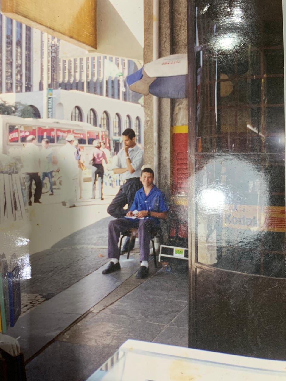 Foto antiga mostra Thiago Landes em ponto de engraxate na Avenida Paulista: de Franco da Rocha, paulista exibia sapatos lustrados e revistas masculinas para atrair mais clientes na calçada.