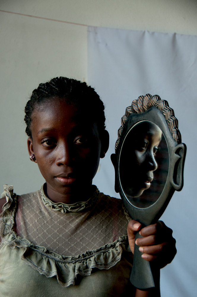 Emilsania do Rosário com um espelho, por Felismino Trindade.