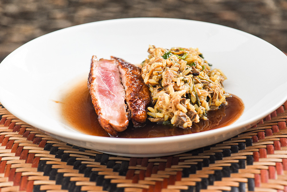 Pato no tucupi servido com arroz e o peito da ave finalizado no carvão