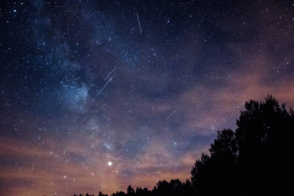 Imagem mostra céu noturno repleto de meteoros