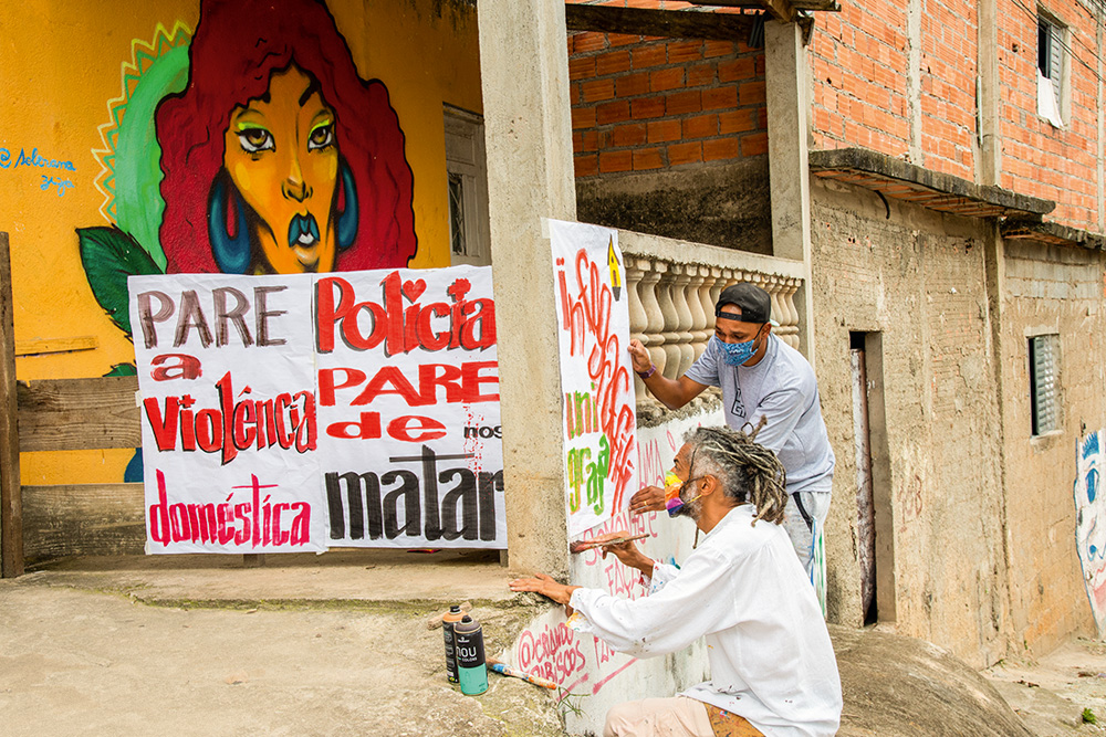 Neri pintando cartazes junto com alunos do projeto Imargem