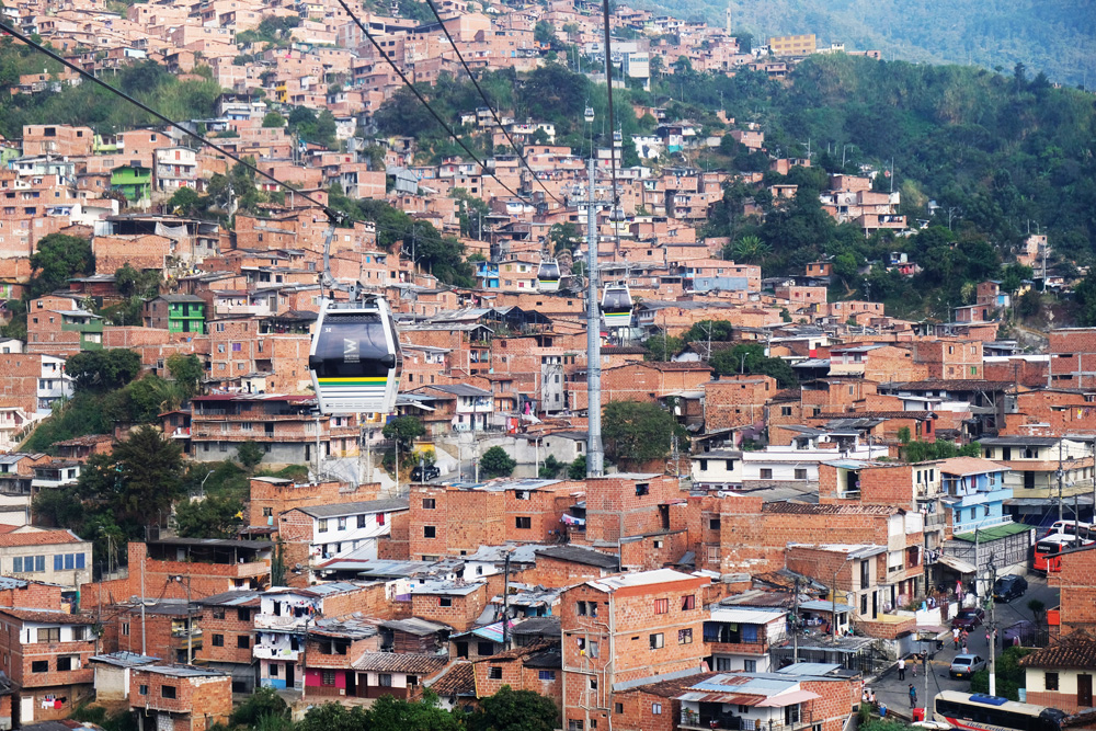 Imagem de um teleférico sobrevoando uma comunidade de Medellín