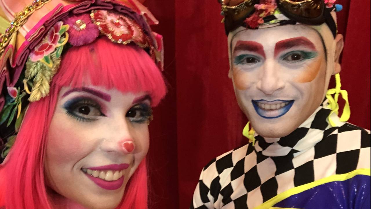 Imagem do casal com maquiagem e trajes circenses