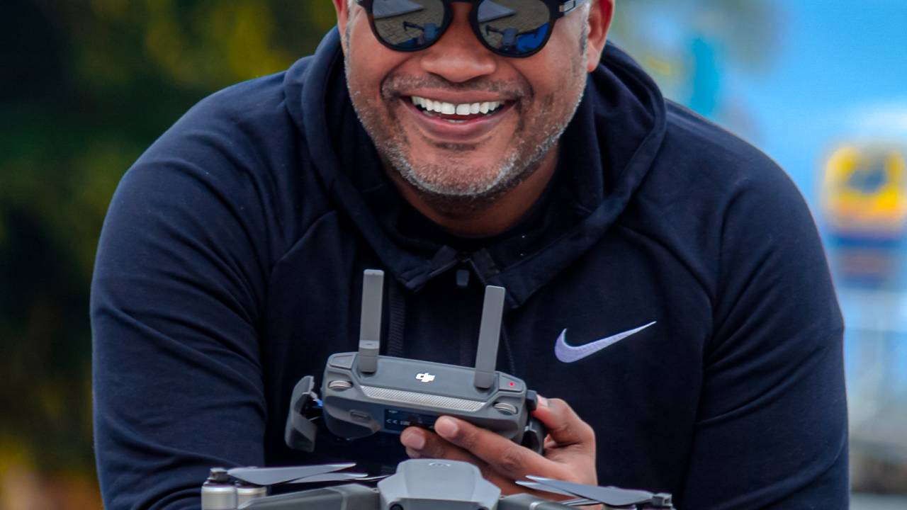 De boné, moletom e óculos escuros, Ricardo Cyrillo segura drone e controle remoto nas mãos.