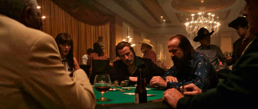 Atores em uma mesa de pôquer durante o filme "A Rosa Envenenada"