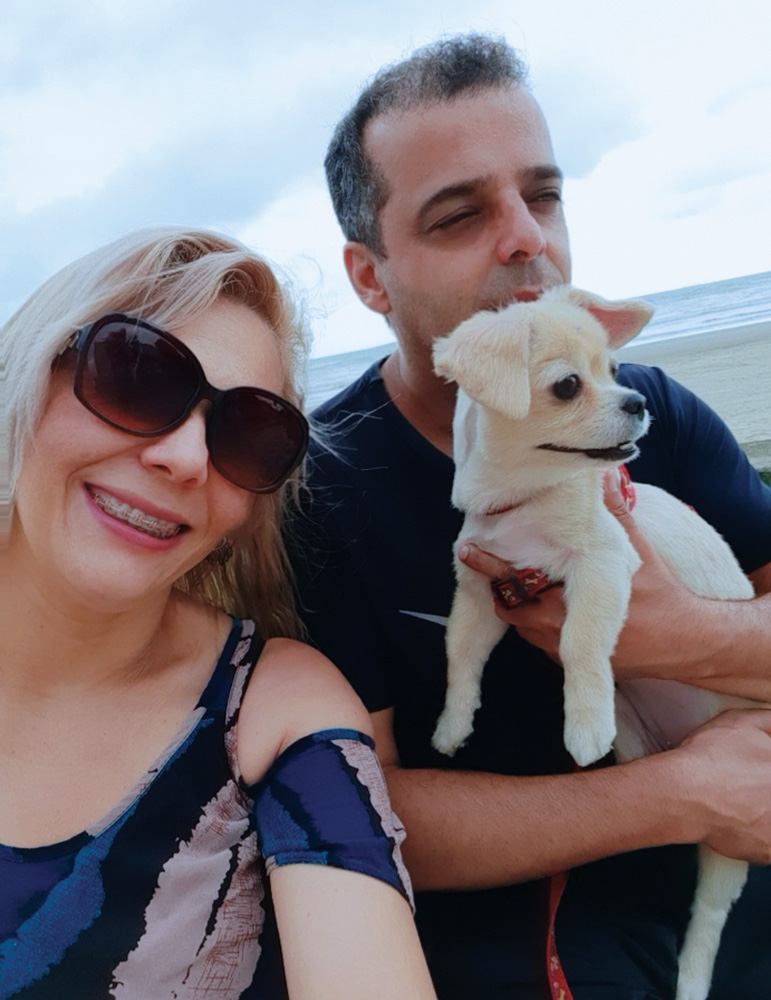 Telma e Clodoaldo passeando na praia com uma cachorrinha no bolo