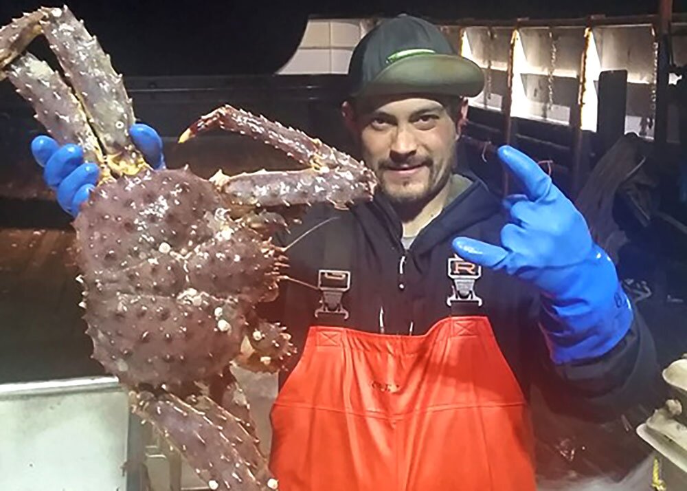 Imagem mostra o pescador Mahlon Reyes, da série Pesca Mortal, segurando enorme caranguejo