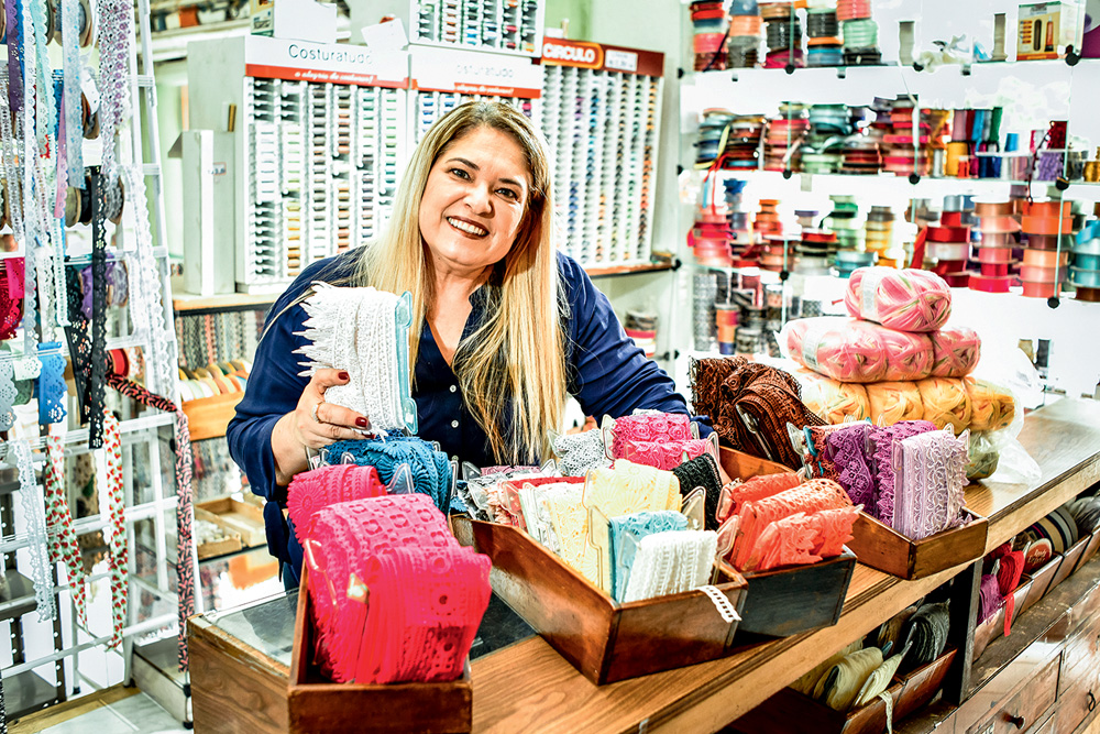 Alessandra Carvalho sorrindo em sua loja