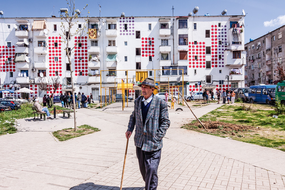 Um idoso caminhando nas ruas de Tirana