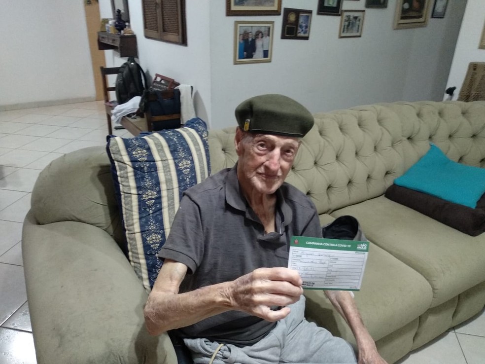Miguel Garofalo, de 99 anos, exibe carteira de vacinação.