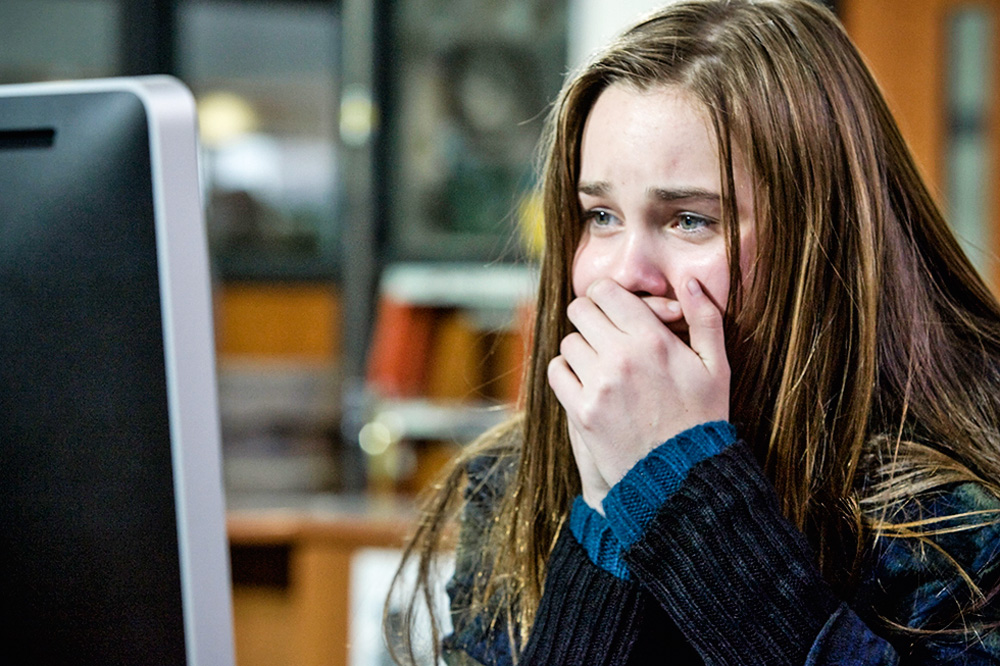 menina chorando na frente do computador