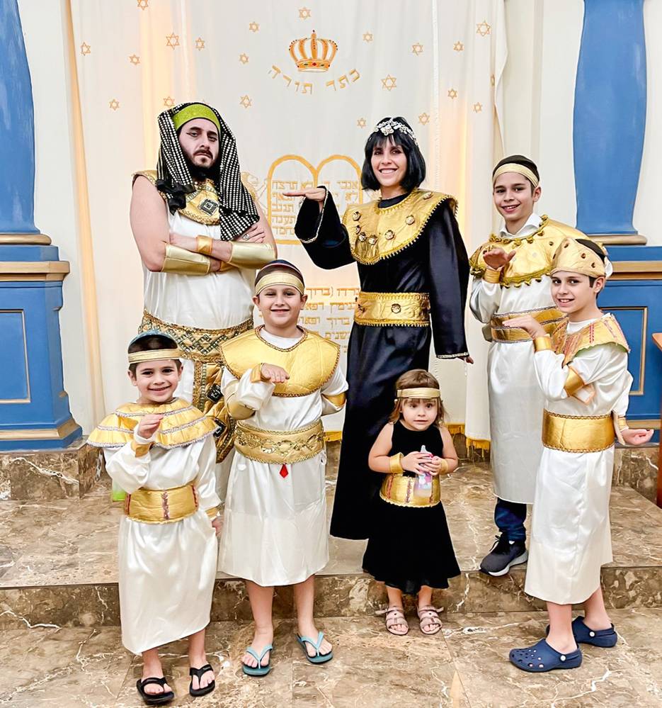 Pedro, sua mulher e os filhos vestidos para a festa de Purim posando para a foto