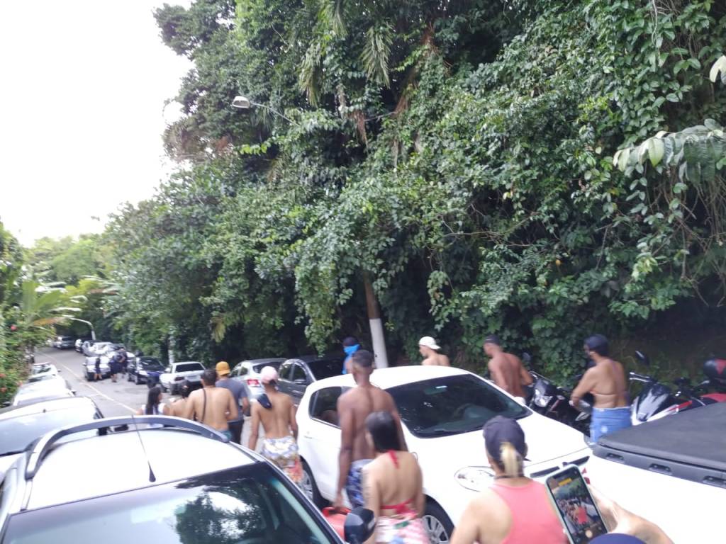Imagem mostra jovens em rua cheia de carros, saindo de praia no Guarujá